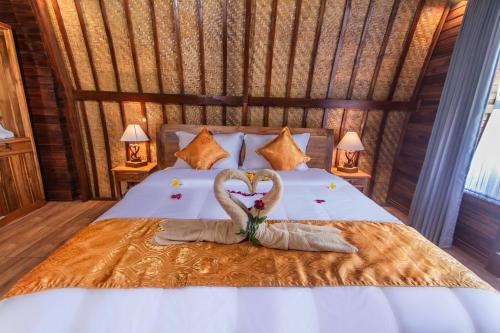 a bed with two swans making a heartshape at Mailaku House in Kerobokan