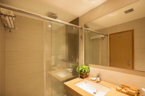 a bathroom with a sink and a shower with a mirror at Sea Shell Port Blair in Port Blair