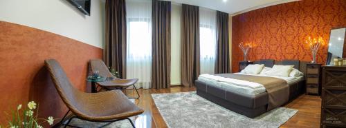 1 dormitorio con 1 cama y 2 sillas en Pollushof Panzió és Étterem, en Csolnok