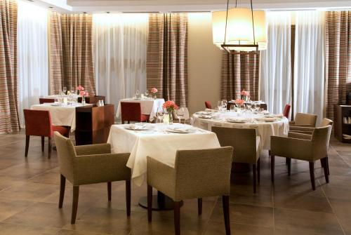 a dining room with white tables and chairs and a chandelier at Grace Cafayate in Cafayate