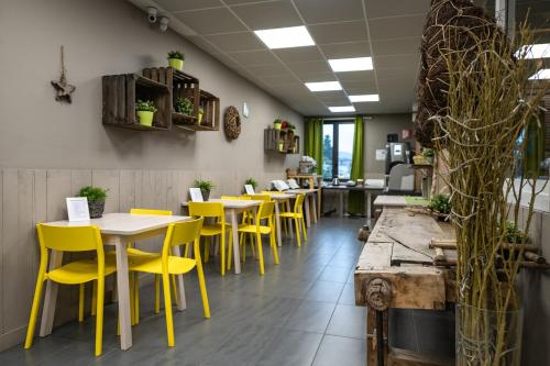 a row of tables and yellow chairs in a restaurant at Dannunziano Aparthotel in Chieti