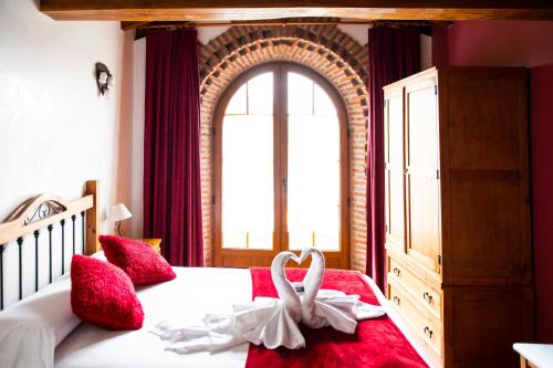 a bedroom with a bed with two swans on it at Posada La Fabula in Santillana del Mar