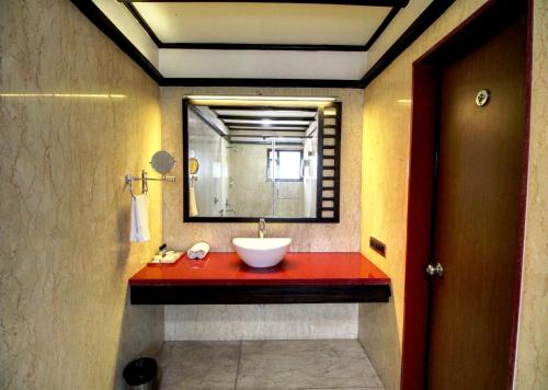 a bathroom with a sink and a mirror at Damanganga Valley Resort Silvassa in Silvassa