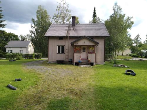 una pequeña casa en un campo con un patio en Art House & Sculpture Garden, en Mänttä
