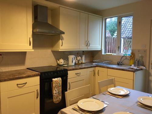 uma cozinha com armários brancos e um forno de fogão preto em Countryside townhouse 