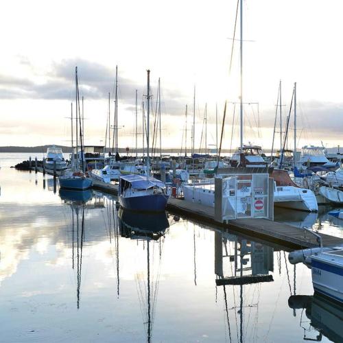 a group of boats docked at a dock in the water at Mantra Hervey Bay in Hervey Bay