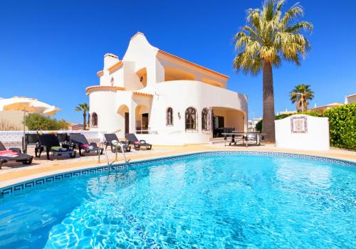 a villa with a swimming pool in front of a house at Villa Morais by Algarve Vacation in Guia