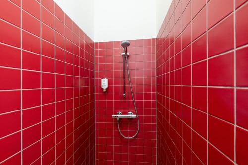 a red tiled shower in a red tiled bathroom at Hotel am Großen Waisenhaus in Potsdam