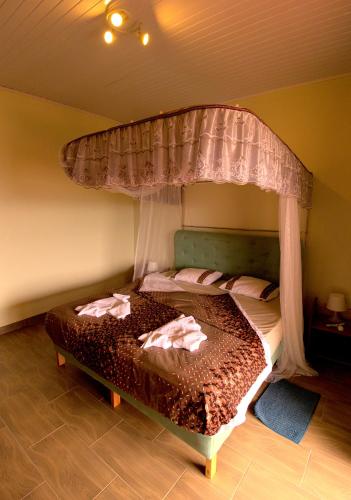 a bedroom with a bed with a canopy at Villa Belle Vue in Kigali