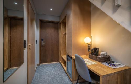 a room with a wooden desk and a hallway at Kultahippu Hotel & Apartments in Ivalo