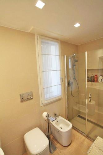 a bathroom with a shower and a toilet and a sink at Pineta Suite in Cervia