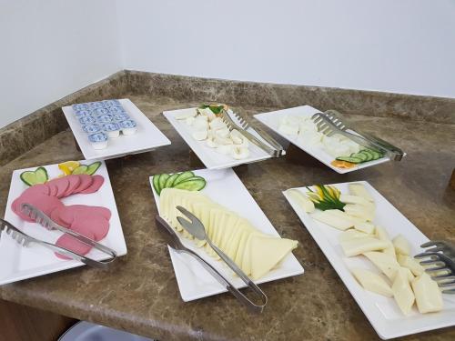 a table topped with plates of food and utensils at OLYMPIC HOTELS Belek in Belek