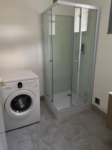uma máquina de lavar roupa e uma cabina de duche em vidro na casa de banho em la maison de laligier em Jaujac