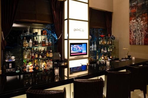 a bar in a restaurant with a television behind it at Phoenix Hotel by HHG in Hakuba