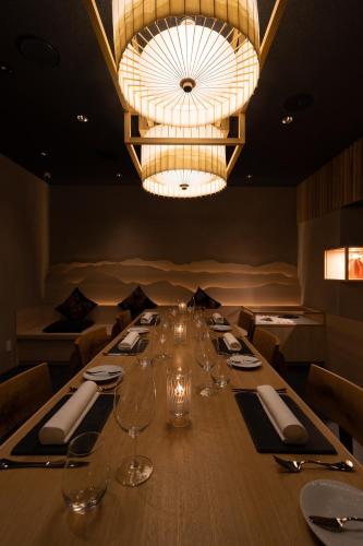 a long table in a restaurant with a chandelier at Phoenix Hotel by HHG in Hakuba