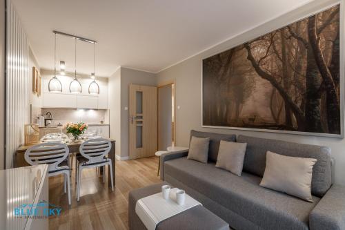 a living room with a couch and a table at Apartamenty BlueSky - Przemysłowa in Karpacz