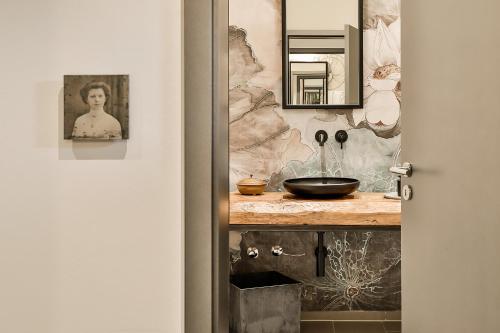 a bathroom with a counter with a sink and a mirror at WeinHotel Fritz Walter in Niederhorbach