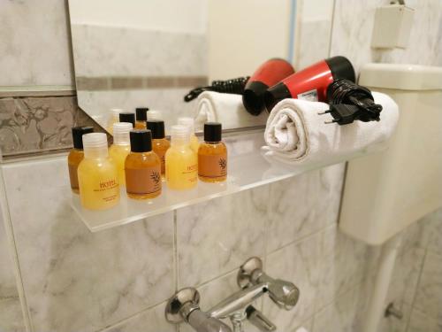 a shelf with four bottles of soap and a roll of toilet paper at Villa Marija Ulcinj in Ulcinj