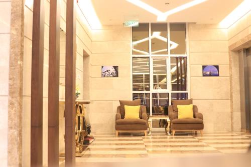 un hall avec deux chaises dans un bâtiment dans l'établissement فندق درة الرؤية, à Djeddah