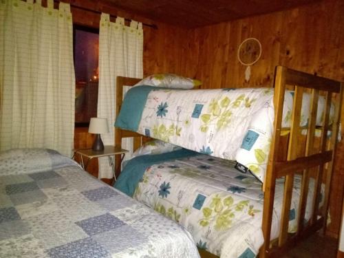 a bedroom with two bunk beds in a cabin at CABAÑA INTERIOR VILLARRICA in Villarrica