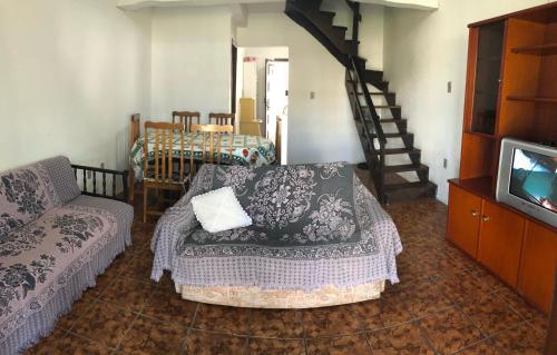Una sala de estar con un sofá y un televisor. en Residencial Raupp, en Capão da Canoa