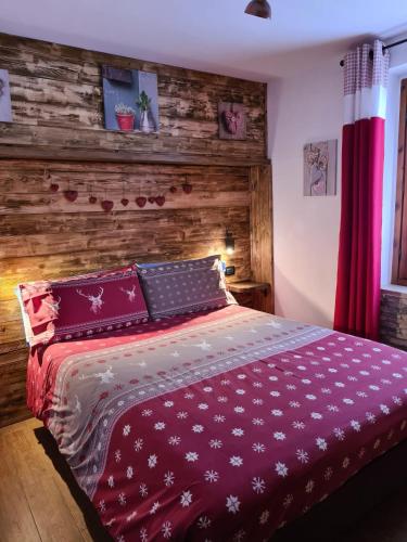 a bedroom with a bed with a wooden wall at Appartamento Gentiana psdCIR0037 in Pré-Saint-Didier