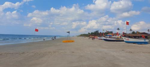 a beach with two boats and flags on it at 'Golden Sunset' 3bhk beach villa in Benaulim