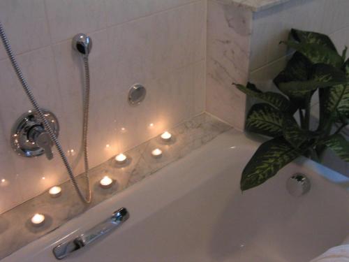 明登的住宿－馬貝拉餐廳酒店，浴室配有带灯的浴缸。