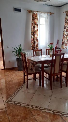 a dining room with a wooden table and chairs at Bajusz Vendégház in Tornyosnémeti