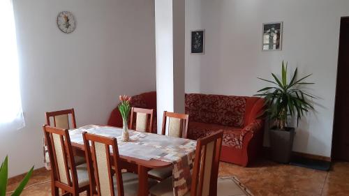 a dining room with a table and chairs and a couch at Bajusz Vendégház in Tornyosnémeti
