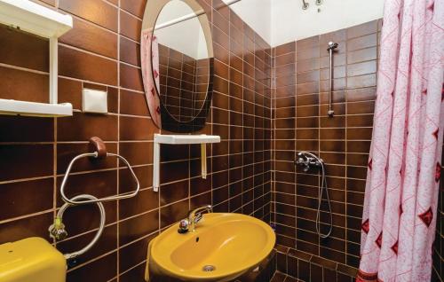a bathroom with a yellow sink and a mirror at Guest House Tanja in Babino Polje