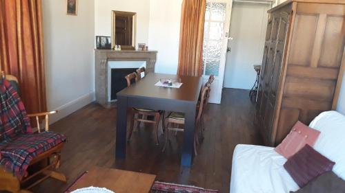 une salle à manger avec une table et une cheminée dans l'établissement appartement 