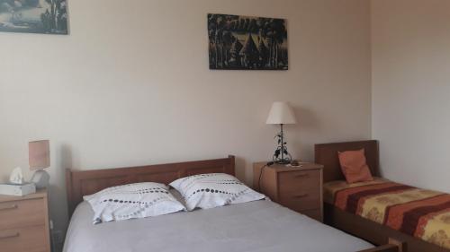 a bedroom with a bed and a desk and a chair at appartement "les goumis" in Baccarat