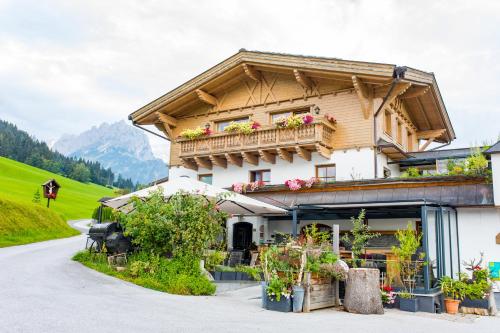 a building with a balcony with flowers on it at Hotel und Alpen Apartments mit Sauna - Bürglhöh in Bischofshofen