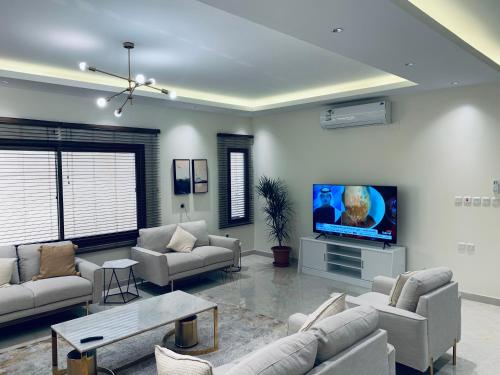 a living room with couches and a flat screen tv at Luxury fully furnished villa ڤيلا مؤثثة in AlUla