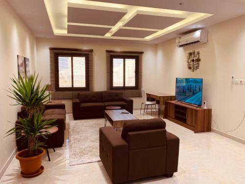 a living room with a couch and a tv at Luxury fully furnished villa ڤيلا مؤثثة in AlUla