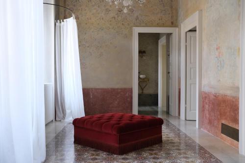 a red couch sitting in the middle of a room at Palazzo Albricci Peregrini in Como