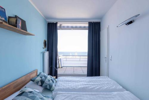 Un dormitorio con una cama y una ventana grande en Ferienwohnung Pier 1167, en Schilksee