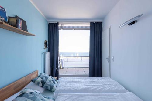 a bedroom with a bed and a large window at Ferienwohnung Pier 1167 in Schilksee