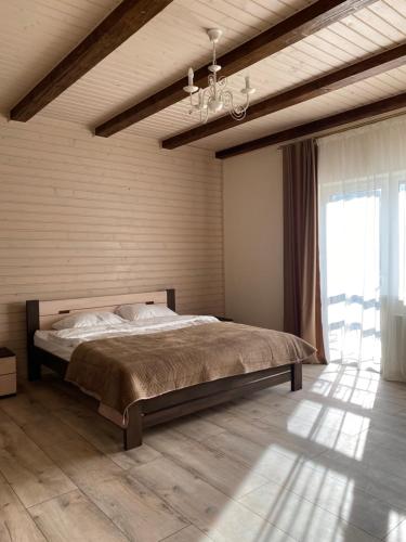 a bedroom with a large bed and a large window at Солодкий Гранат in Slavske