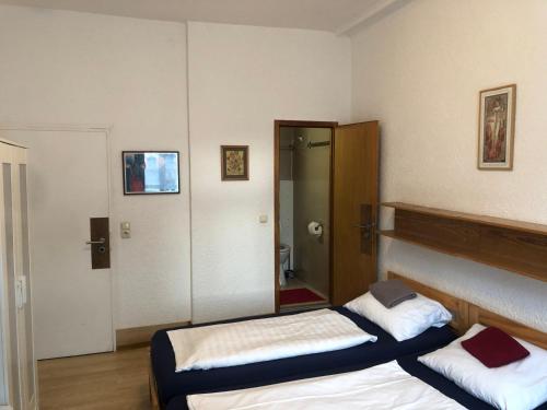 a bedroom with two beds and a mirror at Hotel Pension Schmellergarten in Munich