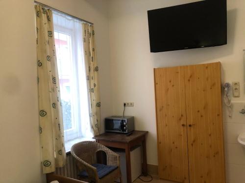 a room with a window and a television on the wall at Hotel Pension Schmellergarten in Munich