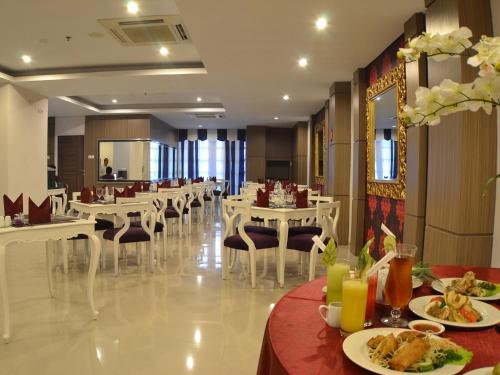 a restaurant with tables and chairs with food on them at The Cube Hotel Malioboro, Azana Hotels Collection in Yogyakarta