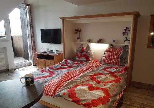 a bedroom with a large bed and a television at Alpenstadel_B18 in Oberstdorf