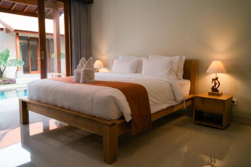 a bedroom with a bed and a large window at The Ume in Canggu