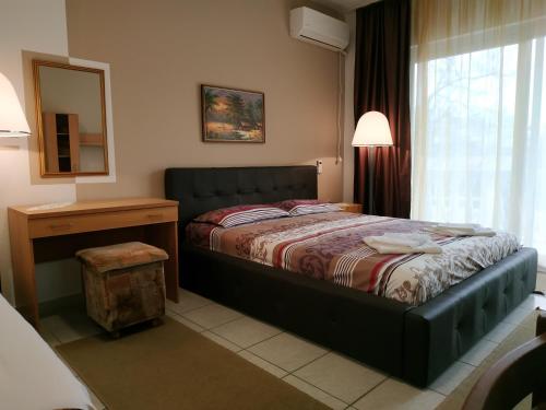 a bedroom with a bed and a table and a window at Villa Marija Ulcinj in Ulcinj