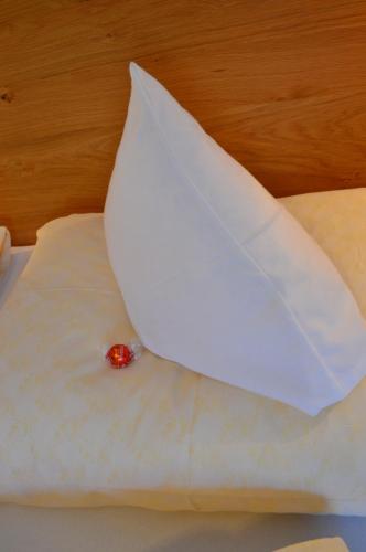 a white pillow with a red ball on top of it at Filzerlehen in Radstadt