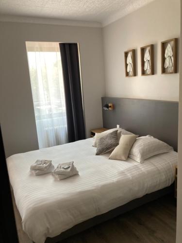 a bedroom with a large white bed with two towels on it at Dolce Vita in Mondorf-les-Bains