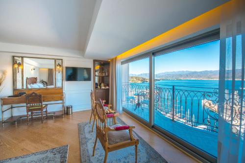 een kamer met een balkon met uitzicht op het water bij Casa Margot Hotel - Adults Only in Fethiye
