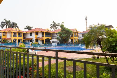 a row of yellow houses with a swimming pool at Villa Knox in Benaulim